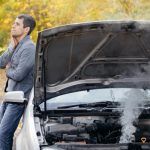 Persoană îngrijorată neștiind de ce iese fum de la motorul mașinii.